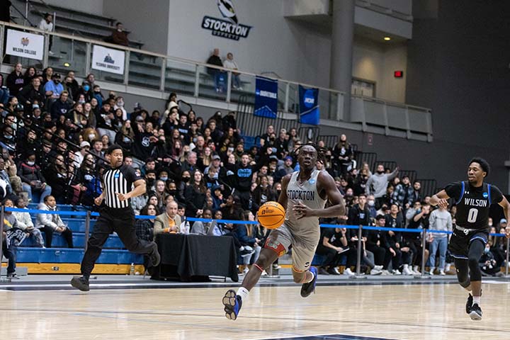 A basketball player running toward the camera on the court
