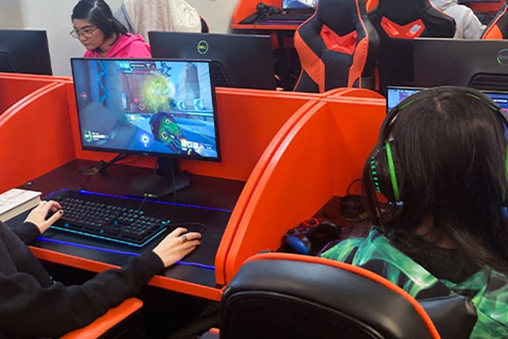 An over the shoulder view of students playing a game on a computer