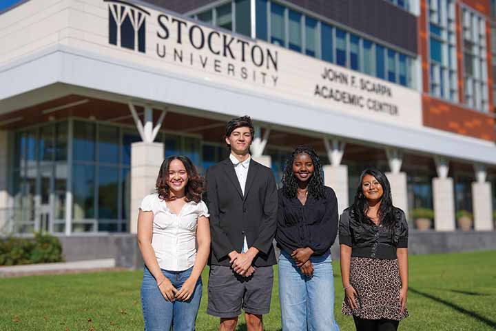 Four students standing on the lawn outside the John F. Scarpa Academic Center in Atlantic City