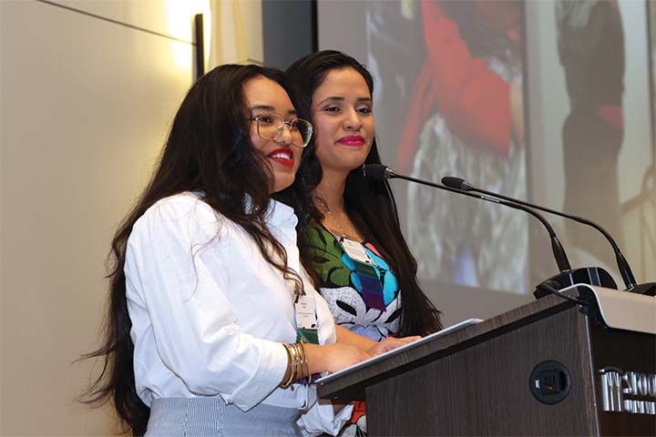 Bryanna and Rubi Ortiz stand behind a podium