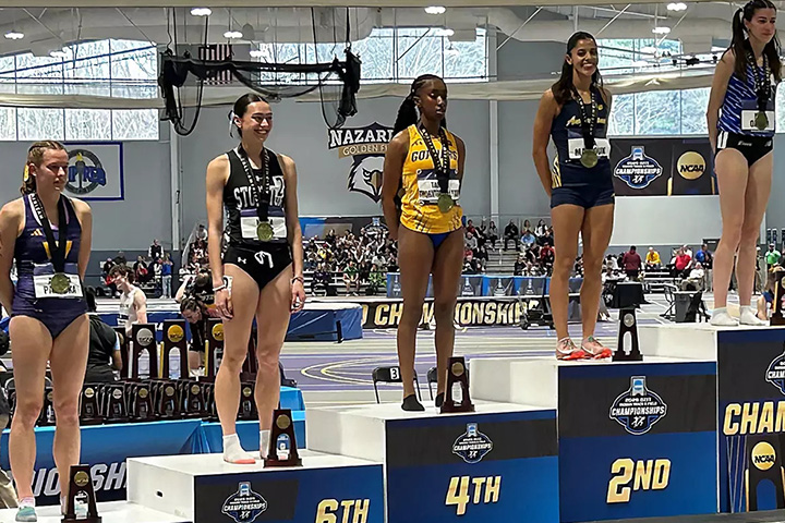 Track and field runners stand on their winners podiums, Kayla Kass second from left