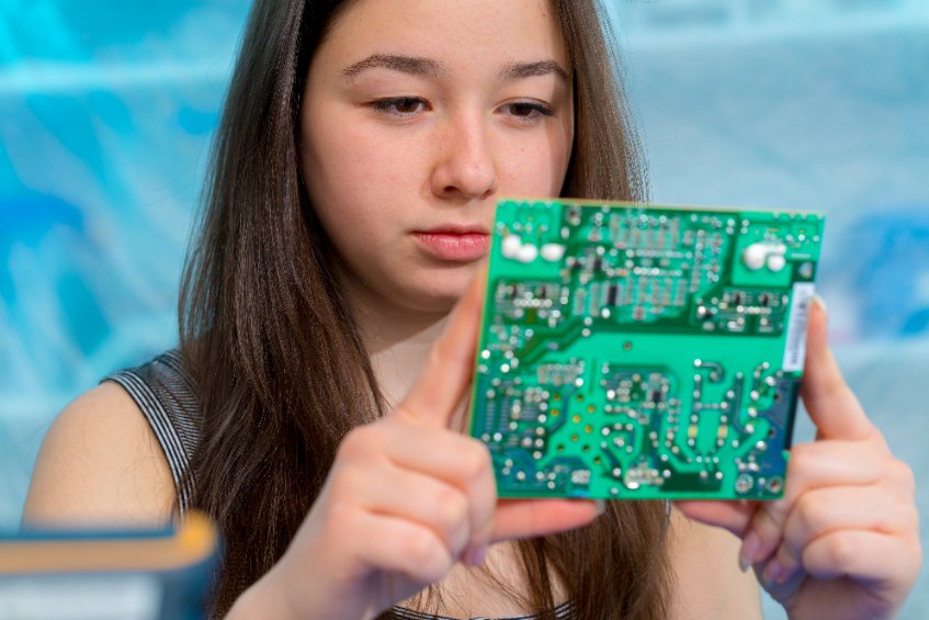 Computer science student Girl examining circuit board