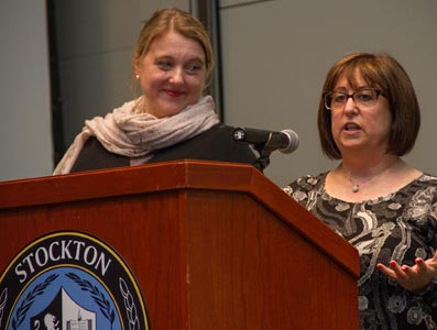 Two women speaking at a podium.