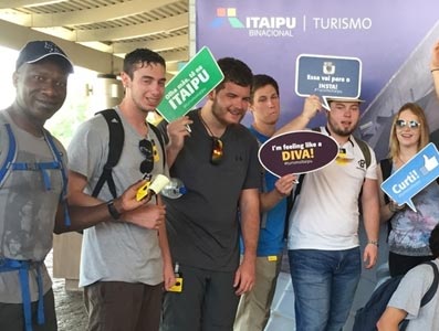 A group of students standing together, smiling and holding playful signs.