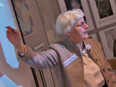 A professor pointing to a powerpoint presentation.