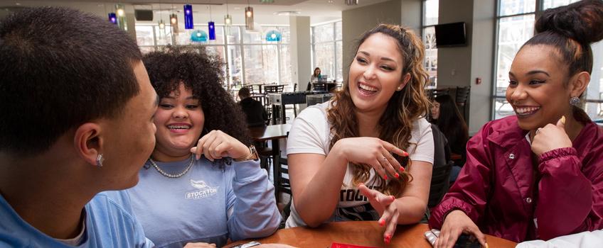 Latin American students in the campus center, smiling and laughing.