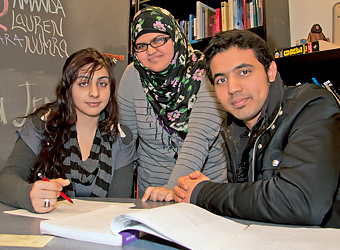 Tutoring Center Students sitting around a table looking at a textbook.