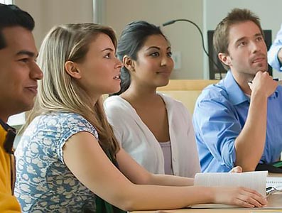 Student sitting at a table, paying attention to a lesson.