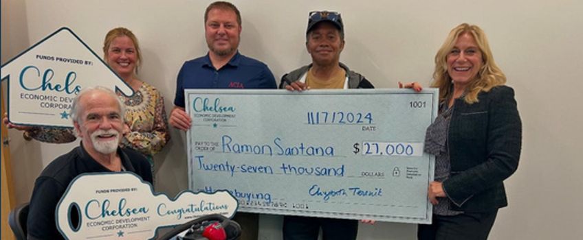 Elizabeth Terenik and Chelsea EDC staff present resident with homebuying grant Elizabeth Terenik and Chelsea EDC staff present resident, Ramon Santana, with an oversized check. Mr. Santana sits at the front holding a giant key.