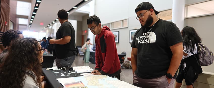 Students talking with representatives of a study abroad program.