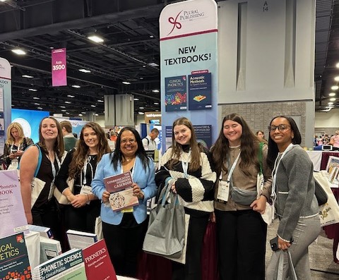 students and professor at booth