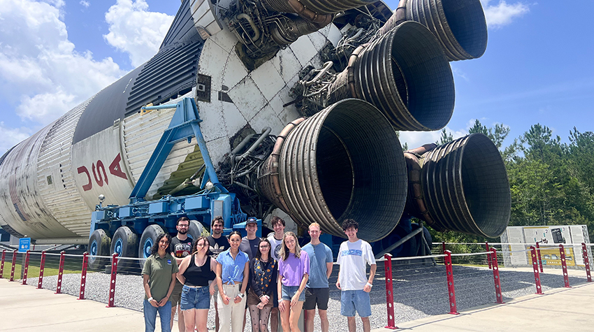 Abby Crawley with her fellow interns at NASA, posing in front of a rocket