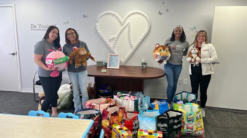 Calli and her colleagues posing for a photo during a holiday drive at the Alcove Center