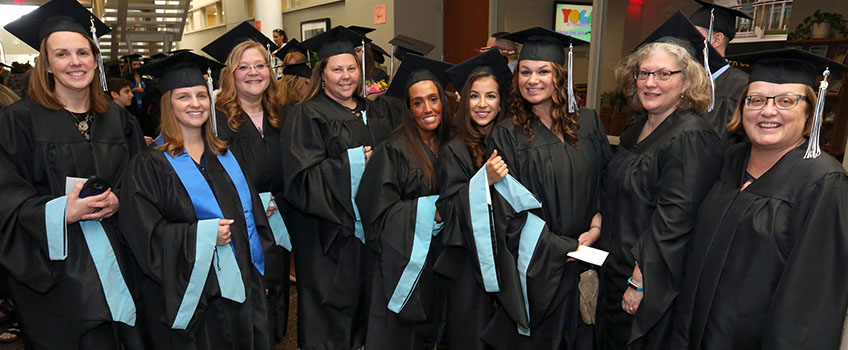 ten teachers in graduation regalia