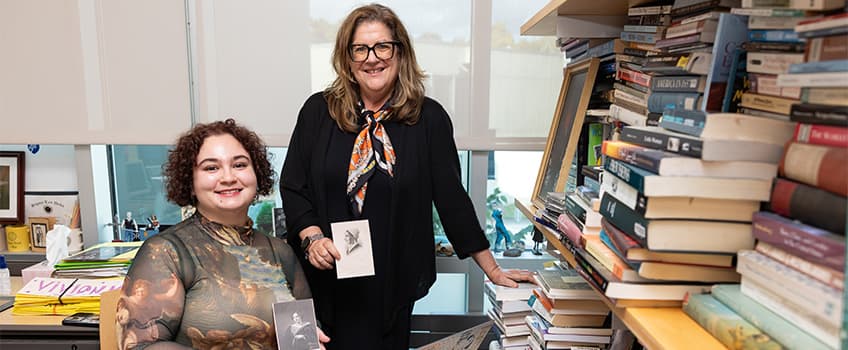 Woman and student behind desk  with books 