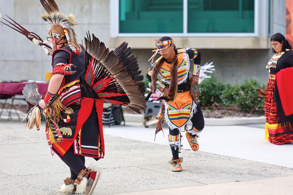 Indigenous dancers perform outside the Multicultural Center