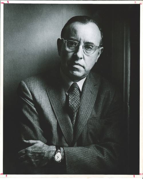 David Riesman in a suit and tie, crossing his arms and looking at the camera, black and white photo
